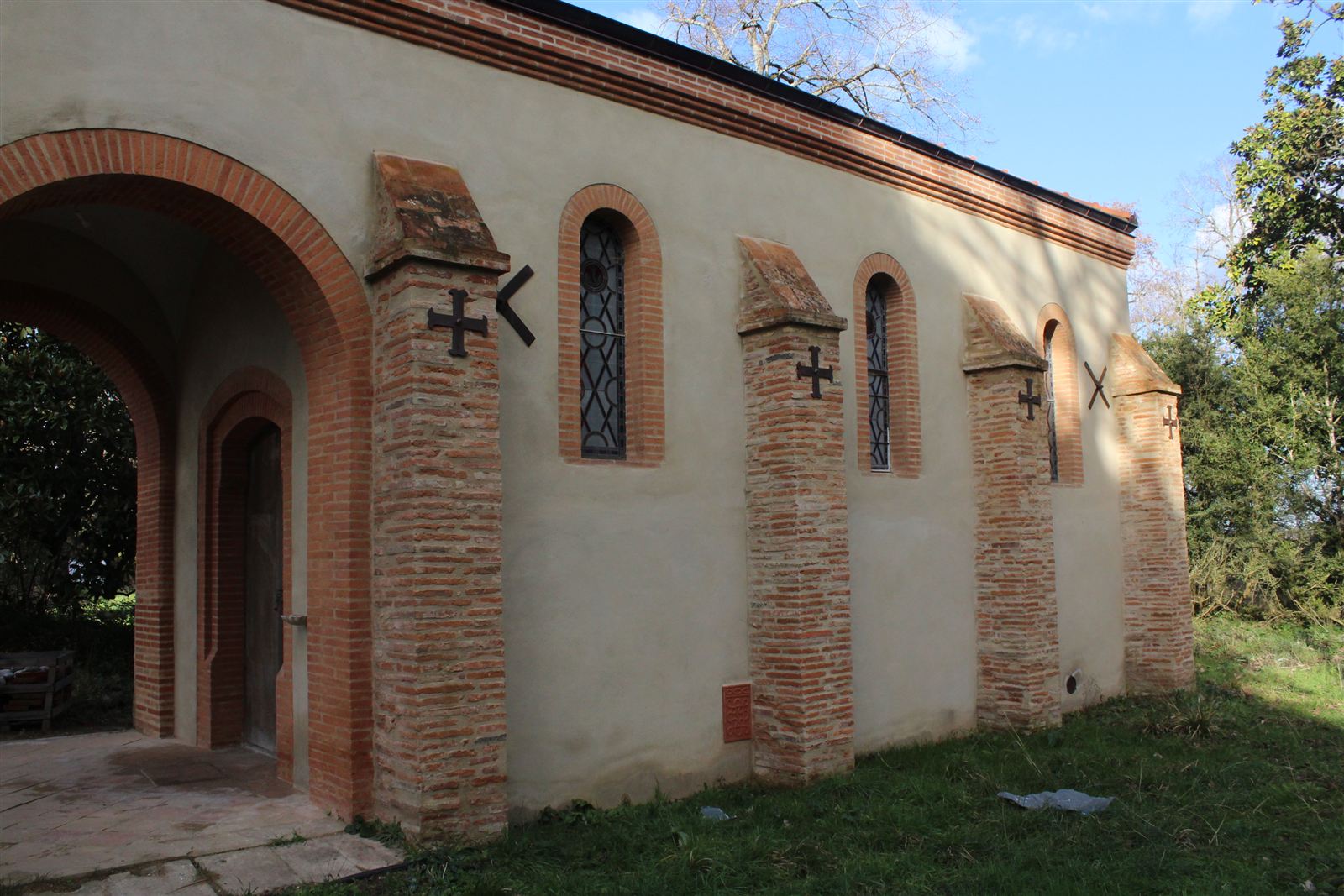 Side of the chapel of Sainte-Lucie with its brick buttresses marked with a cross