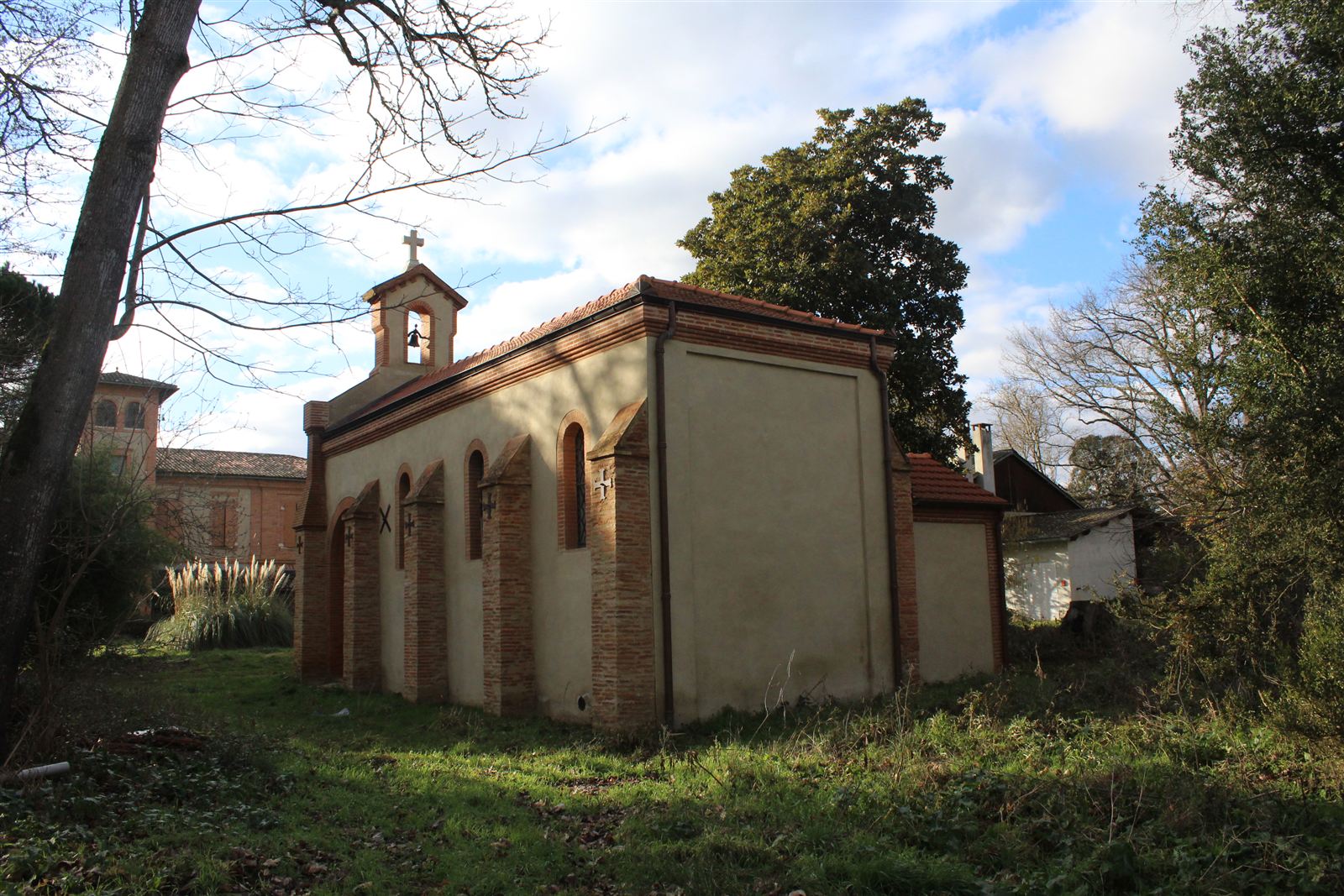 The chapel of Sainte-Lucie in the park, with its bellcote and brick buttresses